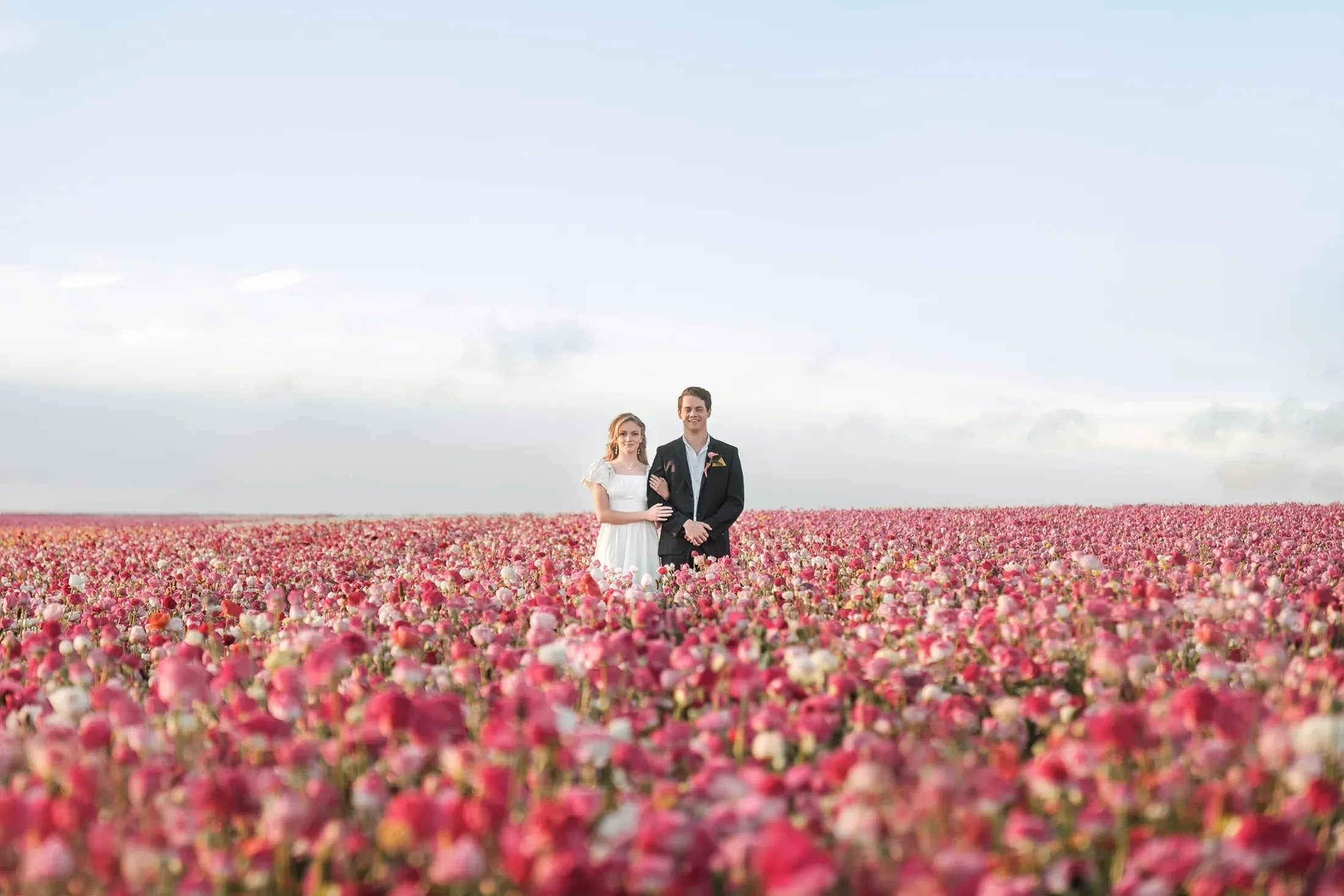 A couple walking hand in hand through a Southern California flower field