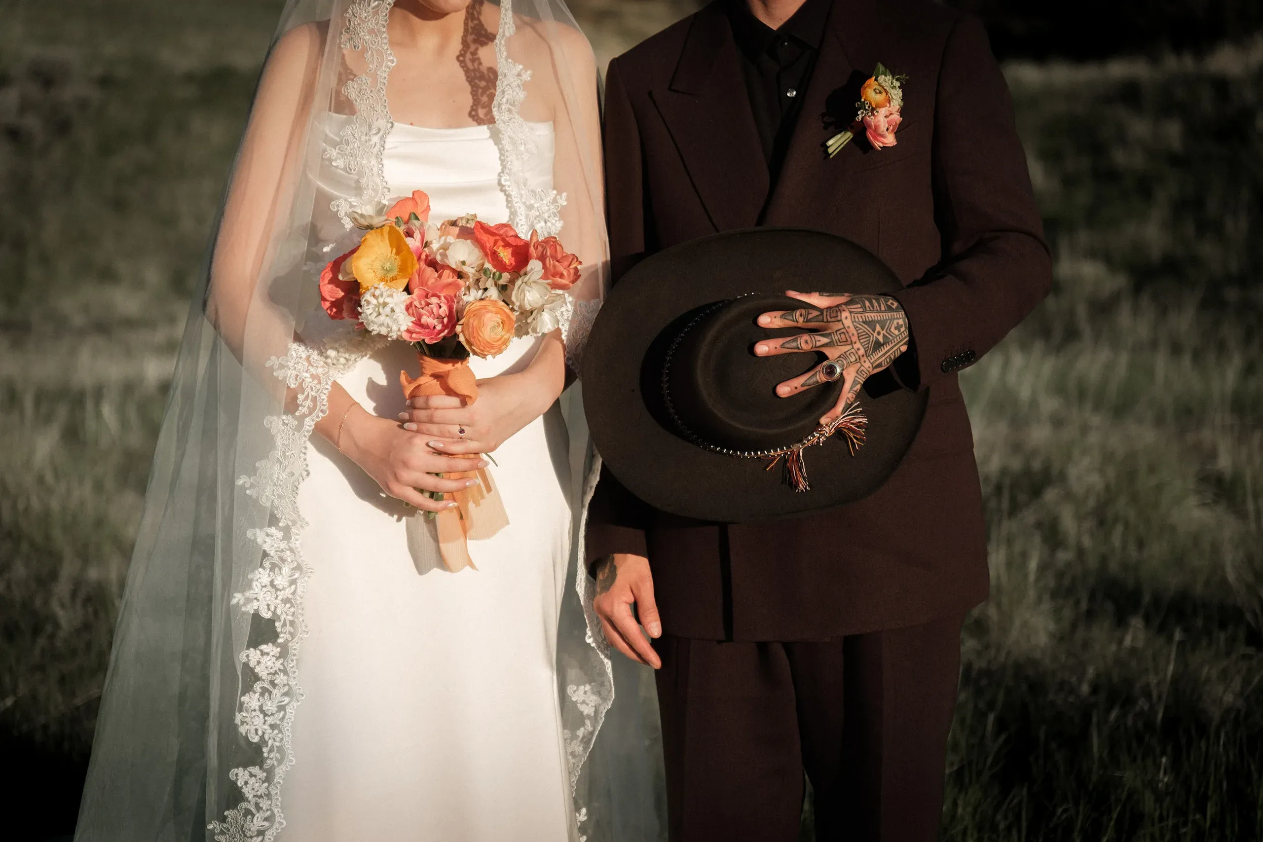 A close wedding portrait of a couple holding flowers